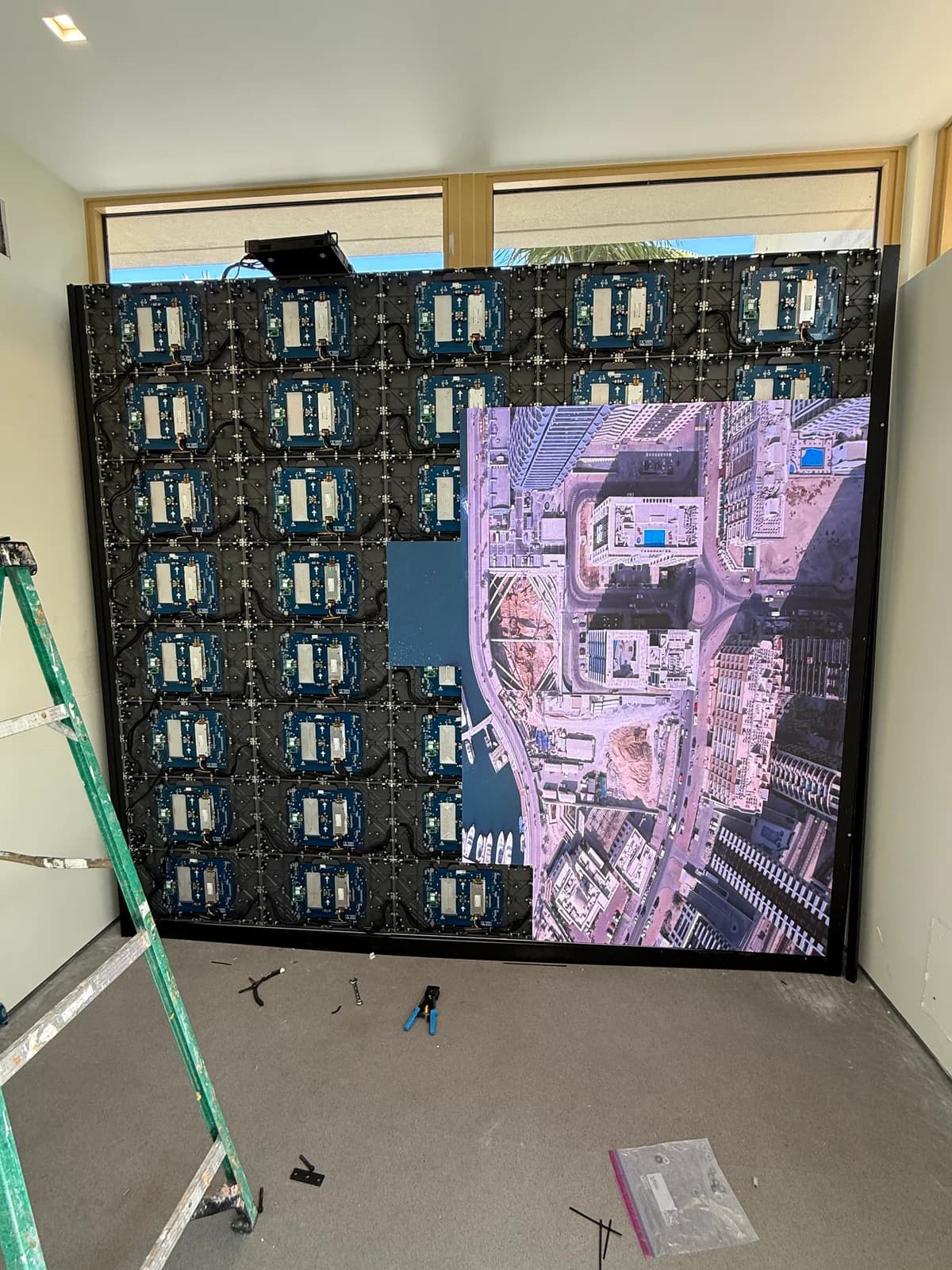 LED video wall mid-calibration showing aerial cityscape on top half