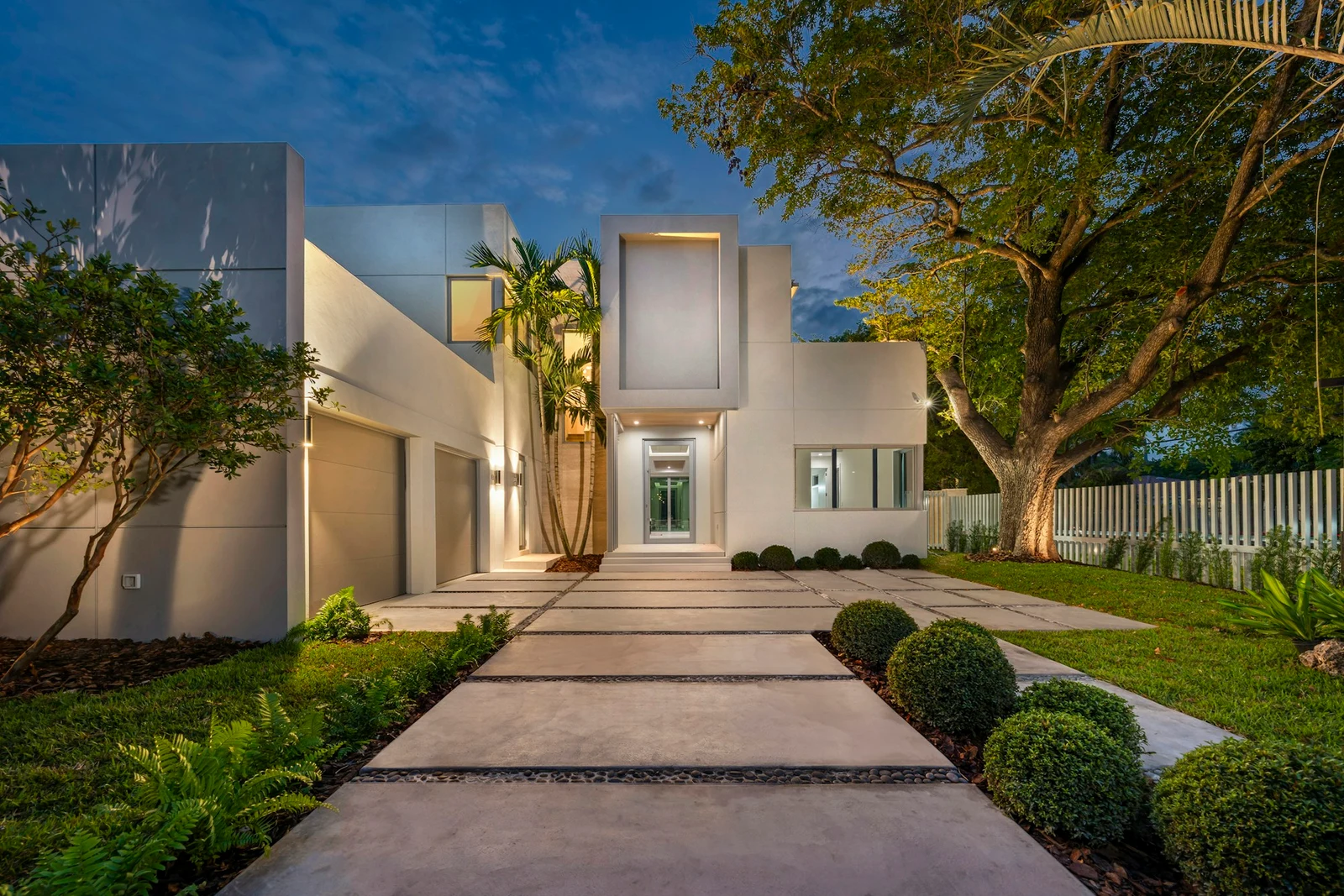 Architectural reference photograph of a modern home entrance at blue hour with warm lighting